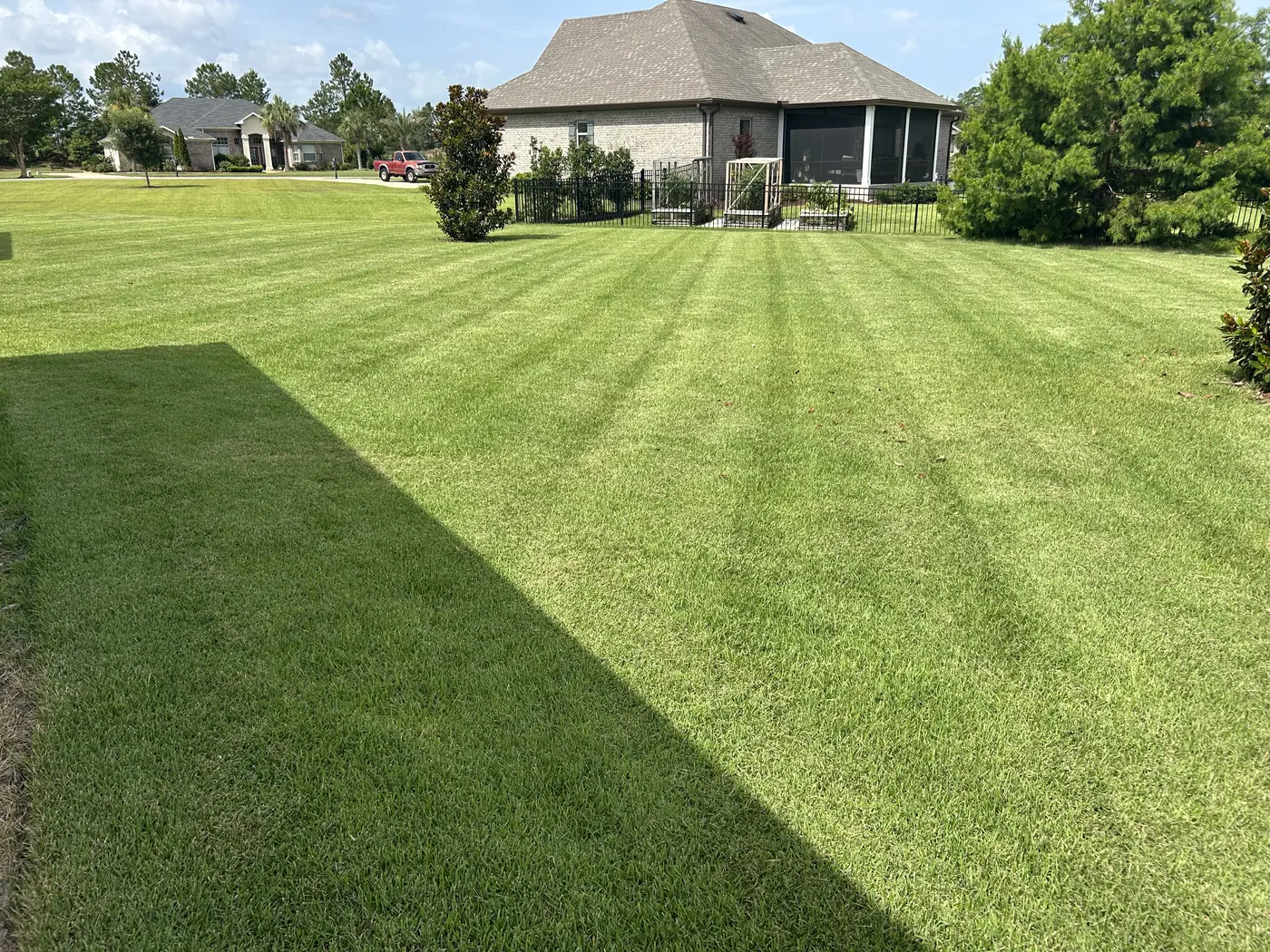 Freshly mowed lawn with clean, straight cut lines beside a home in Freeport, Florida