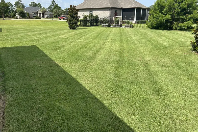 Striped lawn beside a home with a screened lanai in Freeport