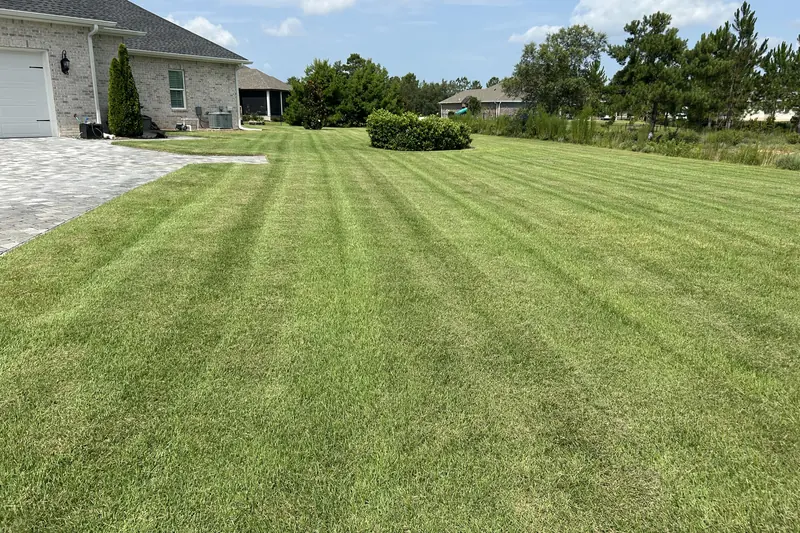 Wide brick-home lawn with fresh mowing lines